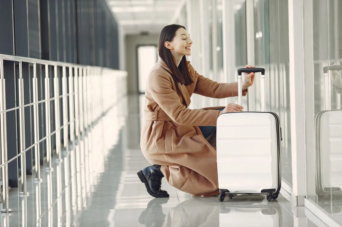 Woman with luggage inside an airport terminal
